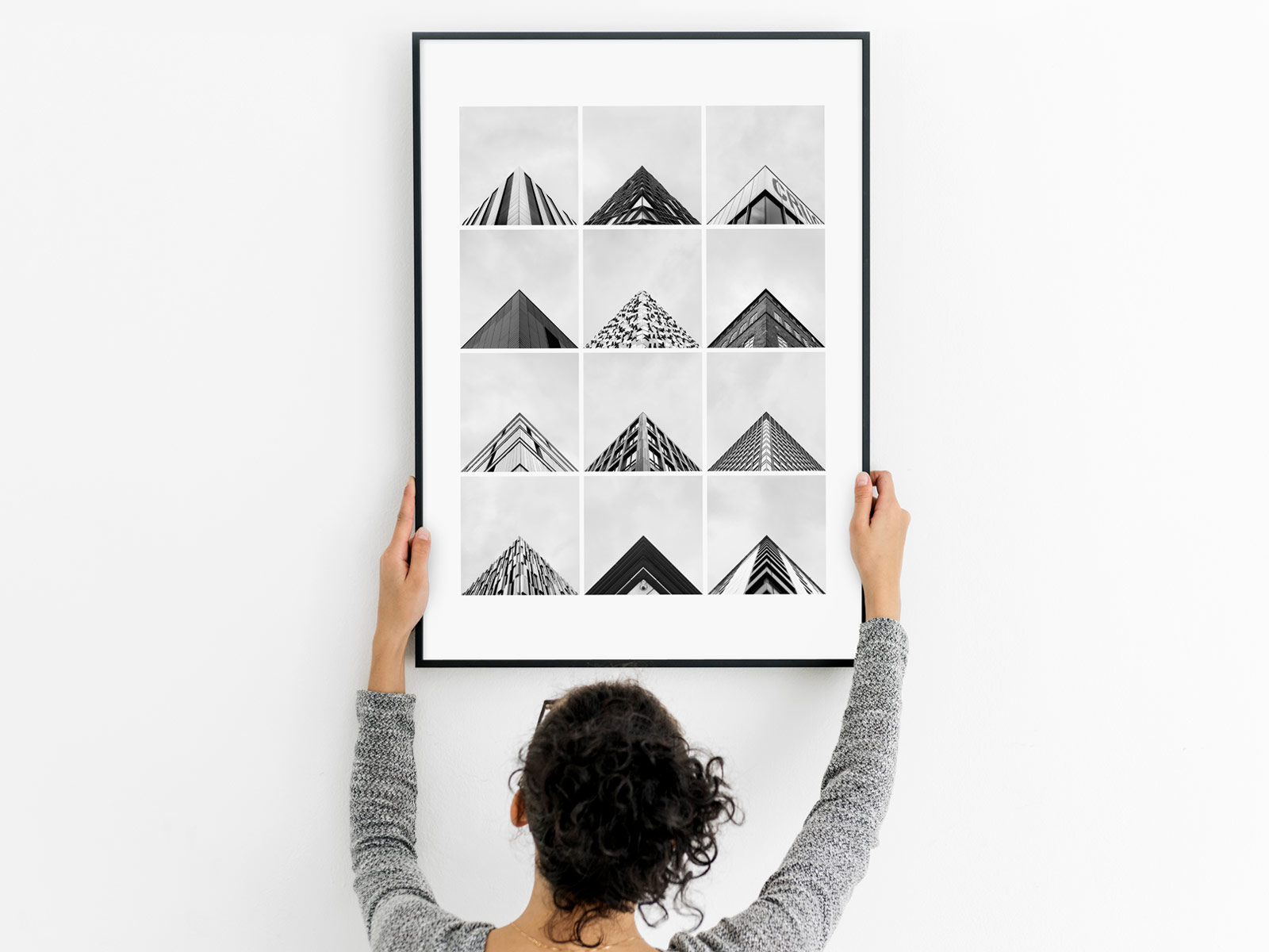Woman holding a framed print of Sheffield's architecture photographed in the Geometry Club style